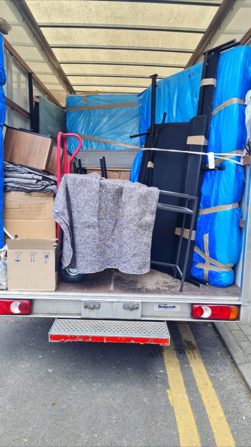 Furniture wrapped in blankets and plastic, loaded in a Luton van